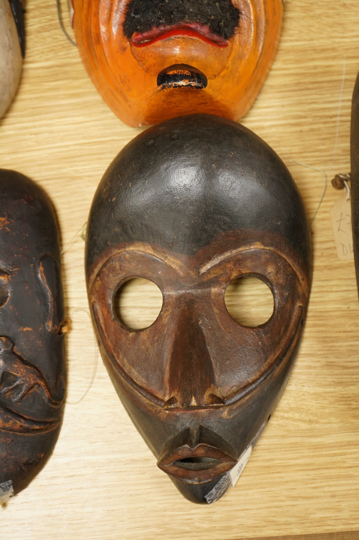 A collection of seven Nepalese, African and Indonesian masks to include a Magar example and one from the Dan Tribe, Liberia, largest 40cm